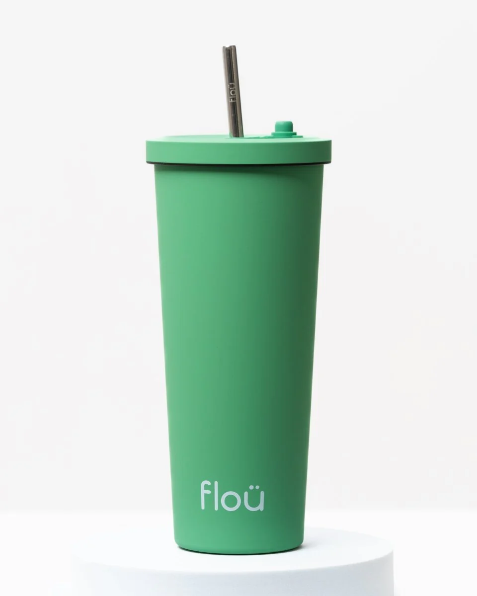 Green cocktail tumbler with a straw